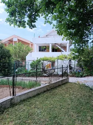 a fence in front of a white house at Apartment M2 Pine tree Sutomore in Sutomore