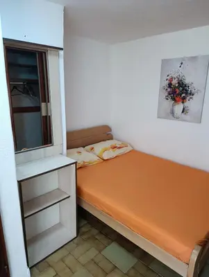 a small bed in a room with a window at Dvokrevetna soba, Spaso in Petrovac na Moru