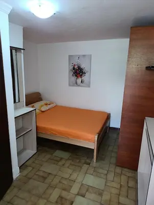 a small room with a bed with an orange sheet at Dvokrevetna soba, Spaso in Petrovac na Moru