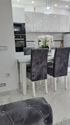 a white kitchen with a white table and chairs at Apartments Pepdjonovic in Ulcinj