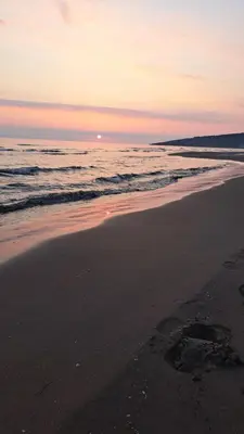 a beach with a sunset and the ocean at Apartments Pepdjonovic in Ulcinj