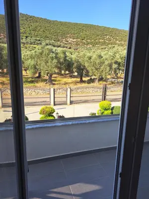 a window with a view of a fence and trees at Apartments Pepdjonovic in Ulcinj
