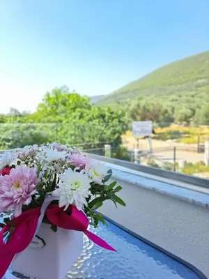a bouquet of flowers in a bucket on a balcony at Apartments Pepdjonovic in Ulcinj