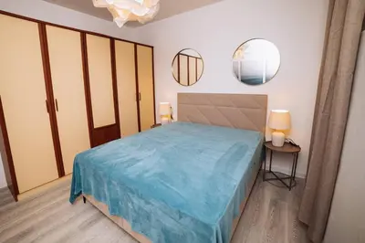 a bedroom with a bed and two mirrors on the wall at Apartment Sveti Stefan in Sveti Stefan
