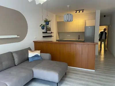 a living room with a couch and a kitchen at Apartment Sveti Stefan in Sveti Stefan