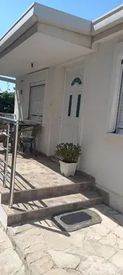 a porch of a house with a table and a plant at Apartman Olgica in Sutomore