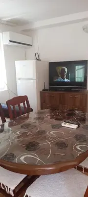 a living room with a table and a tv at Apartman Olgica in Sutomore