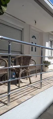 a railing on a porch with a table and chairs at Apartman Olgica in Sutomore