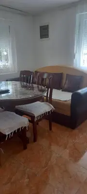 a living room with a couch and a table and chairs at Apartman Olgica in Sutomore