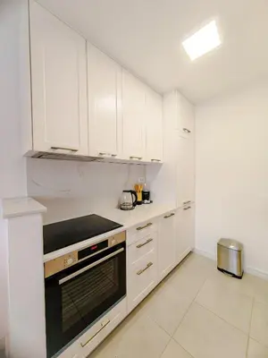 a kitchen with white cabinets and a stove top oven at Apartman Petar-Spacious Friendly Stay in the Heart of Budva in Budva