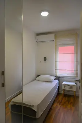 a bedroom with a bed and a glass wall at Apartman Petar-Spacious Friendly Stay in the Heart of Budva in Budva