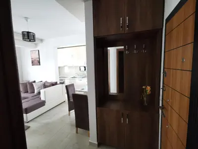 a living room with a brown cabinet and a couch at Ulcinj Vibes & Waves Apartment in Ulcinj