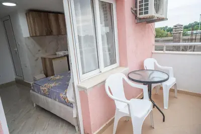 a small room with a table and chairs and a window at Apartments Hamburg in Donji Štoj