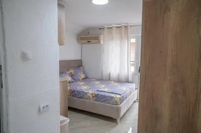 a small bedroom with a bed and a window at Apartments Hamburg in Donji Štoj