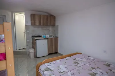 a small room with a bed and a kitchen at Apartments Hamburg in Donji Štoj