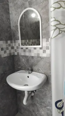 a white sink in a bathroom with a mirror at Domaćinstvo Kvaić in Bar
