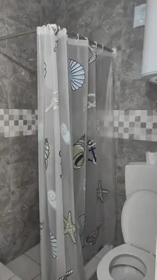 a bathroom with a shower curtain with a toilet at Domaćinstvo Kvaić in Bar