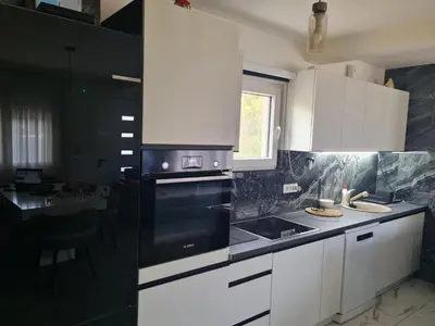 a kitchen with white cabinets and a black stove top oven at Villa Passaggio Private Pool & Tranquil Stay Near the Sea in Bar