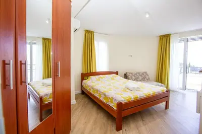 a small bedroom with a bed and a window at Oliva home in Utjeha