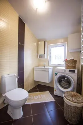 a bathroom with a toilet and a washing machine at Oliva home in Utjeha