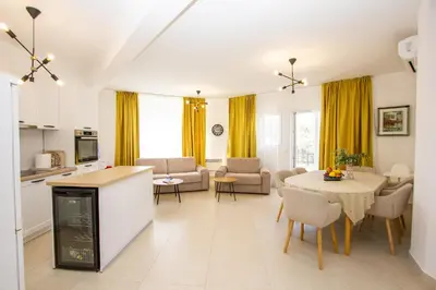a kitchen and living room with a table and chairs at Oliva home in Utjeha