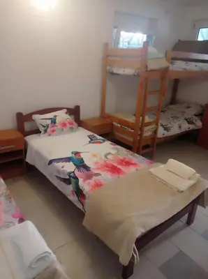 a bedroom with two bunk beds and a chair at Apartman Rogonjić in Sutomore