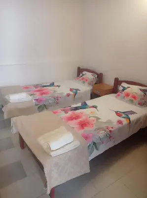two beds in a room with flowers on them at Apartman Rogonjić in Sutomore
