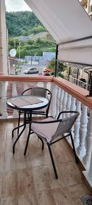 a table and chairs on a balcony with a view at Apartmani Pavlović in Becici