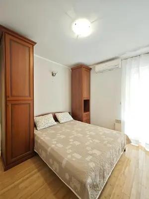 a bedroom with a bed and a wooden cabinet at Apartment Olea in Becici