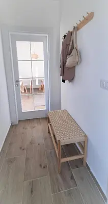 a room with a bench in front of a door at Larimar Cozy Apartment in Ulcinj