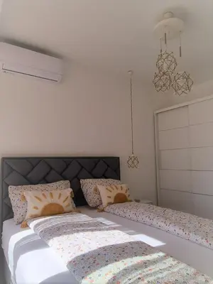 a bedroom with two beds and a chandelier at Larimar Cozy Apartment in Ulcinj