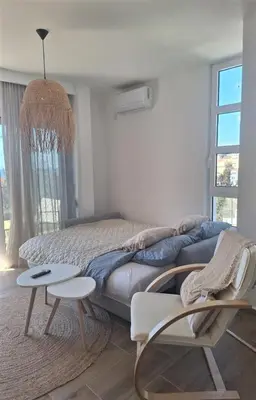 a bedroom with a bed with two chairs and a table at Larimar Cozy Apartment in Ulcinj