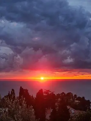 a sunset over the ocean with the sun setting at Larimar Cozy Apartment in Ulcinj