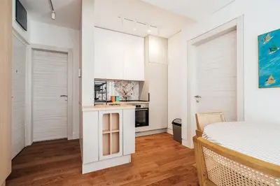 a kitchen with white cabinets and a bed in a room at Przno Gate 114 By In Propety in Pržno