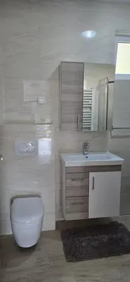 a bathroom with a white toilet and a sink at Inspired by Nature in Podličak