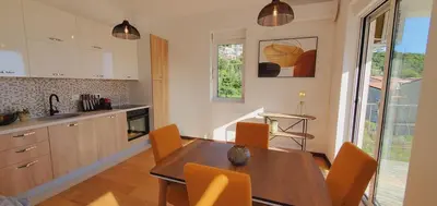 a kitchen with a wooden table and orange chairs at Inspired by Nature in Podličak
