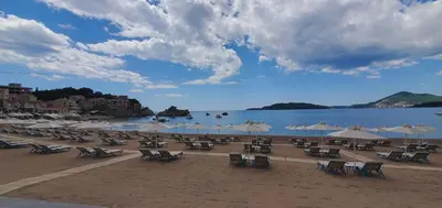 a beach with chairs and umbrellas and the water at Inspired by Nature in Podličak