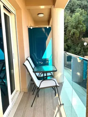 a balcony with two chairs and a table on it at Azure Horizon Pržno in Sveti Stefan