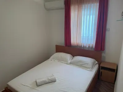 a small bedroom with a bed with a window at New house in Dobra Voda