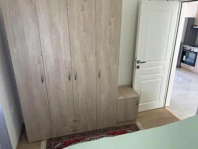 a large wooden cabinet in a room with a door at New house in Dobra Voda