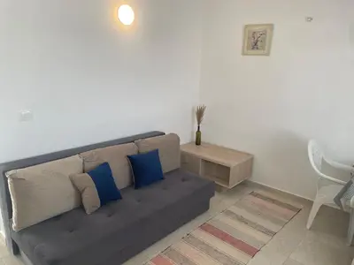 a living room with a couch with blue pillows at New house in Dobra Voda