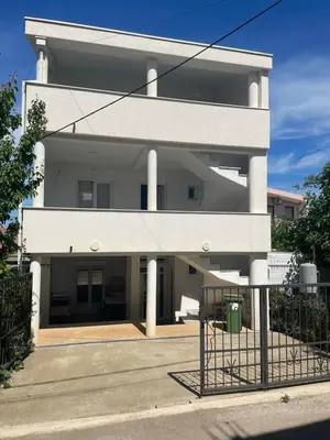 a white building with a fence in front of it at New house in Dobra Voda