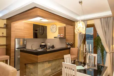 a kitchen with a counter and a dining room at Blanche Cliff Apartments in Sveti Stefan