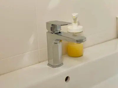a bathroom sink with a faucet and a yellow cup at Belvedere Apartments in Ulcinj