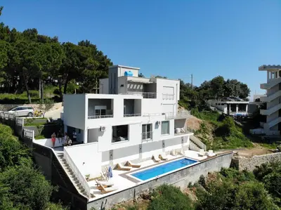 a house on a hill with a swimming pool at Belvedere Apartments in Ulcinj
