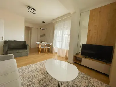 a living room with a white table and a television at Belvedere Apartments in Ulcinj