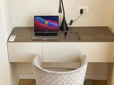 a laptop computer sitting on a desk with a chair at Belvedere Apartments in Ulcinj