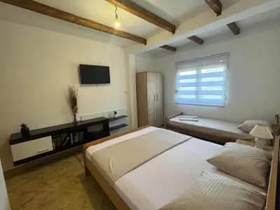 a bedroom with a large bed and a television at Villa Miki in Kruče