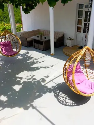two swing chairs on a patio with a living room at Villa Miki in Kruče