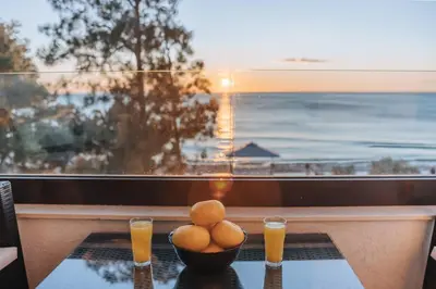 a table with a bowl of eggs and two glasses of orange juice at Apartments Kuce Lekovica Beach & snack bar- Bistro in Bar